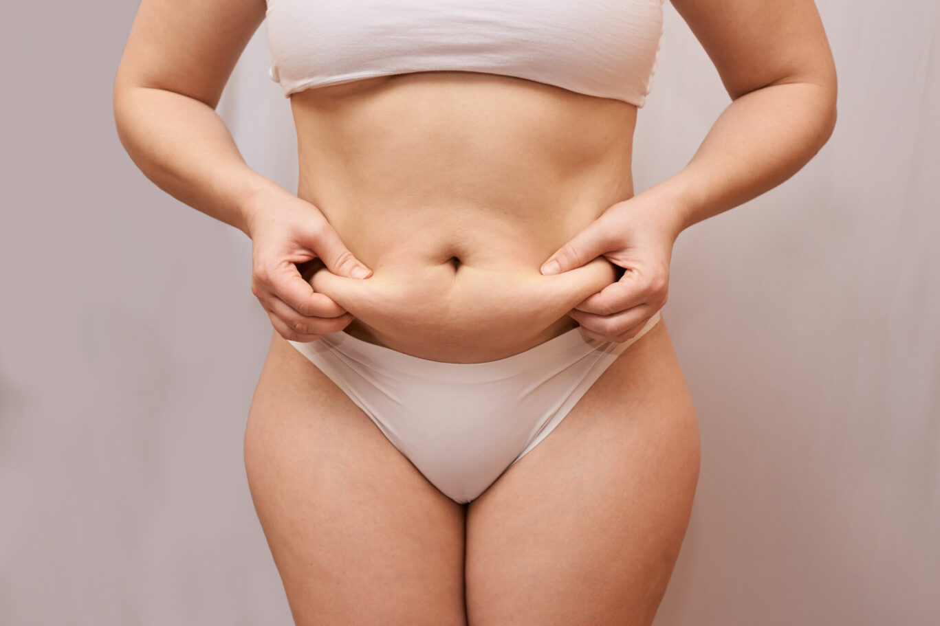 Post weight loss woman body. Pinch belly side. Measurement lady procedure. Medicine